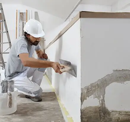 Plaster specialist repairing a cracked plaster wall in an older Clearwater home