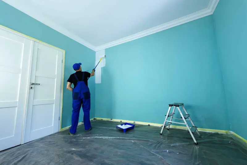 Painter rolling a fresh coat on a prepared interior wall in a Tampa Bay home