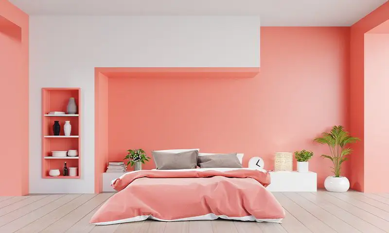 Painter cutting in a straight line along a ceiling edge with an angled brush