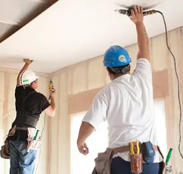 Sunlight raking across a smooth finished drywall wall beside a large window