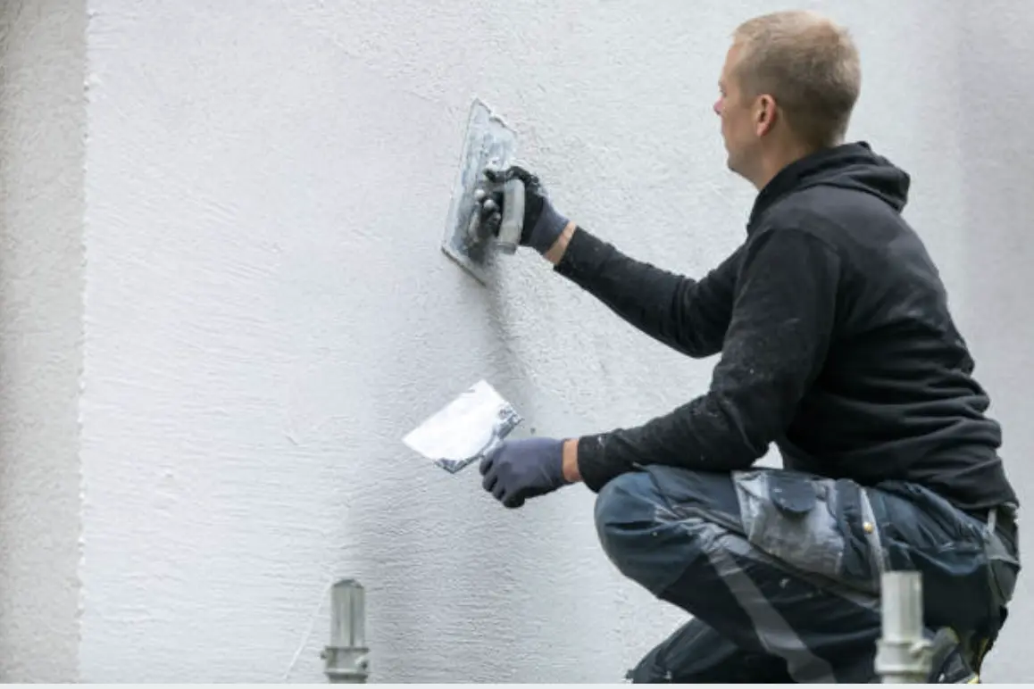 Close-up of a hairline crack in painted stucco on a Florida block home