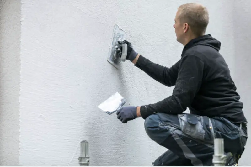 Close-up of a hairline crack in painted stucco on a Florida block home