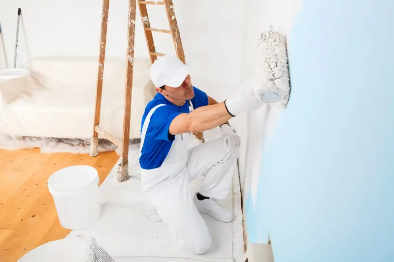 Room prepared for painting with taped trim and drop cloths